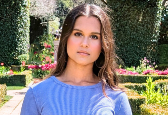 Headshot of Anika Jena, taken outside in a garden